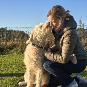Fører med hendene på hunden under massasje og stretching